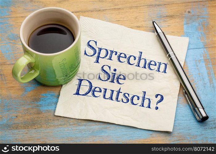 Sprechen Sie Deutsch? Do you speak German? Handwriting on a napkin with a cup of espresso coffee.