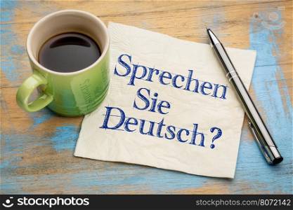 Sprechen Sie Deutsch? Do you speak German? Handwriting on a napkin with a cup of espresso coffee.