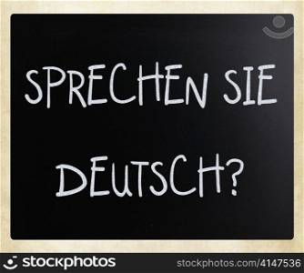 ""Sprechen Sie Deutsch?" handwritten with white chalk on a blackboard"