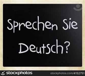 ""Sprechen sie Deutsch" handwritten with white chalk on a blackboard"