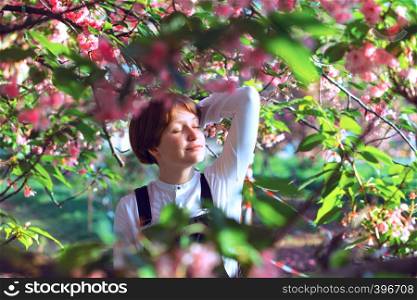 spring - beautiful girl posing in blooming cherry blossoms