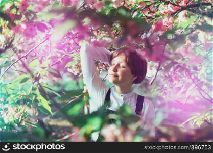 spring - beautiful girl posing in blooming cherry blossoms