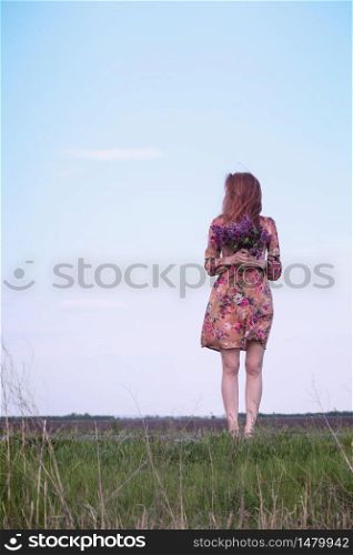 spring - beautiful happy girl with a bouquet of lilacs at the outdoor against the sky