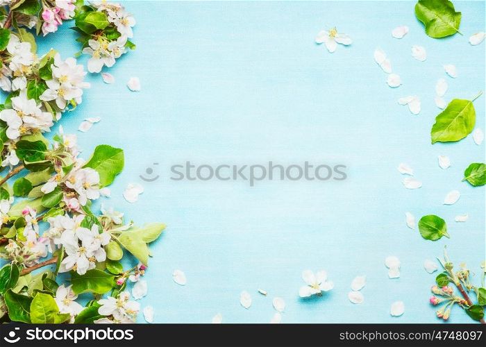 Spring blossom on blue turquoise background, top view, frame
