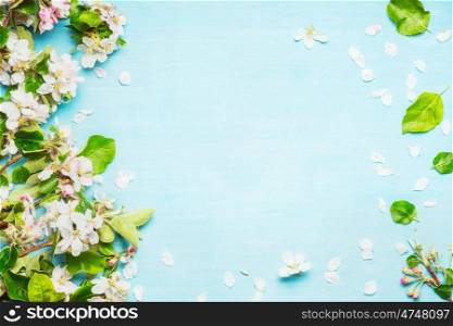 Spring blossom on blue turquoise background, top view, frame