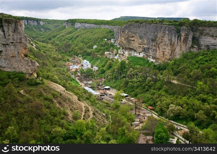 Spring cloudy view of Bakhchisaraj town and Assumption Convent in rock (Chufut Kale, Crimea, Ukraine)