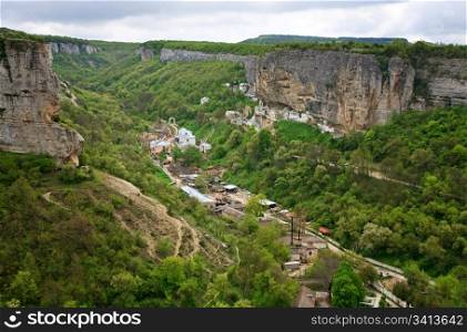 Spring cloudy view of Bakhchisaraj town and Assumption Convent in rock (Chufut Kale, Crimea, Ukraine)