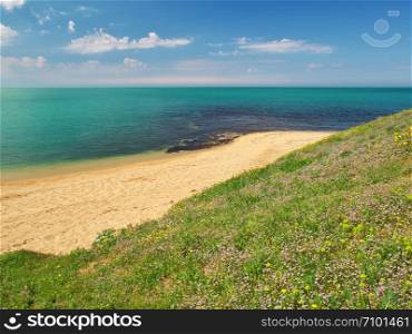 Spring coast on the sea. Sky, sea, and green grass. Nature composition.