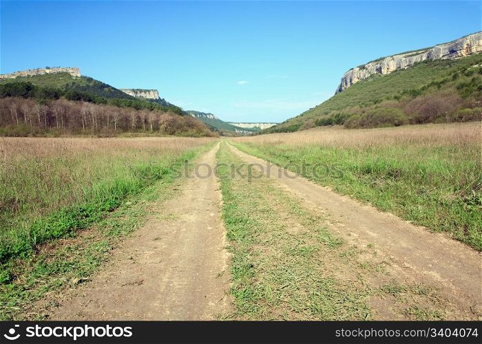 Spring Crimean mountain landscape and rural roads in valley (Mangup Kale - historic fortress and ancient cave settlement in Crimea, Ukraine)