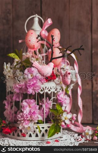 Spring decor - pink birds on the branch in shabby chic cage with flowers. The spring decor