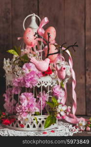 Spring decor - pink birds on the branch in shabby chic cage with flowers. The spring decor