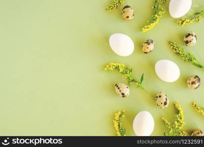 Spring easter floral border. Natural tree branches, yellow flowers and various eggs on green background with copy space. Creative Flat lay Top view Template for your design.. Spring easter floral border. Natural tree branches, yellow flowers and various eggs on green background with copy space. Creative Flat lay Top view Template for your design