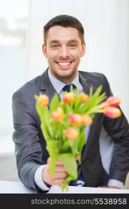 spring, flowers and happiness concept - smiling handsome man giving bouquet of fresh flowers