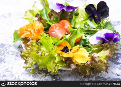 Spring flowers salad. Fresh summer salad with edible flowers and herbs.Clean food