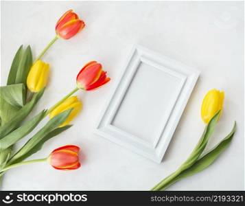 spring flowers with empty frame placed desk