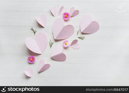 Spring gentle romantic composition with flowers and pink paper hearts on white wooden background. Beautiful background or greeting card for Valentine&rsquo;s Day ore wedding invitation, with copy space