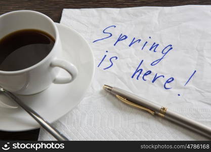 Spring is coming. Spring is here message written on napkin and cup of coffee