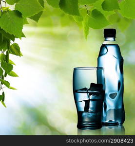 Spring mineral water bottled with glass and ice against natural backgrounds