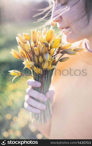 spring mood and feeling of freedom. girl holding a bouquet of yellow wild tulips