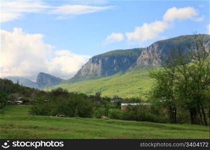 "spring mountain massif landscape and village in foreground (rock "Sokolinuj Vzljot" (Falcon Flying up), near Sokolinoe village, Crimea, Ukraine)"