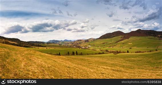 Spring mountain meadow landscape. Panorama of Slovakia Tatras mountains in spring. Mountain village in valley