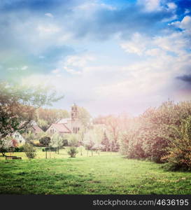 Spring or summer country village background with blooming trees and lawn in park