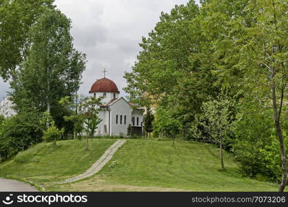 Spring panorama of a part of a residential district neighborhood with a church with modern architecture and belfry, Drujba, Sofia, Bulgaria