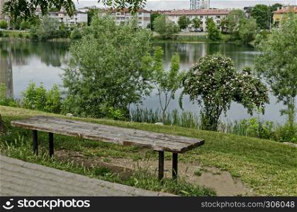 Spring panorama of a part of residential district neighborhood along a lake with green trees, shrubs and flowers, Drujba, Sofia, Bulgaria