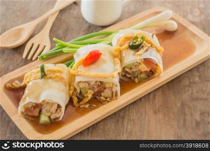 Spring rolls with vegetables and chicken on wooden plate, stock photo