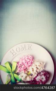 Spring table setting with plate, ribbon and lovely hyacinths flowers , top view, border, pastel color, vertical
