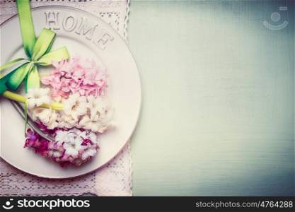 Spring table setting with plate, ribbon and lovely hyacinths flowers , top view, border, pastel color
