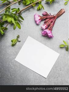 Spring twigs and flowers with blank white paper card , top view