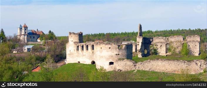 Spring view of Sydoriv Castle ruins (built in 1640s) and Katolitsky church (built in 1730-1741). Sydoriv village, located 7 km south of Husiatyn, Ternopil region, Ukraine. Two shots stitch image.
