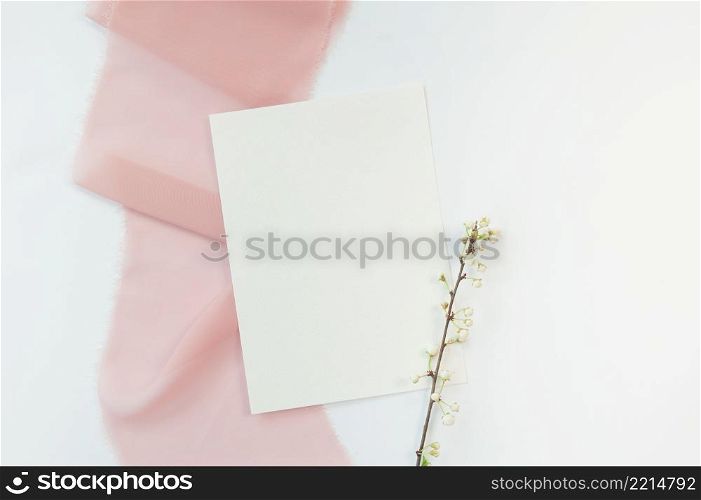 Spring wedding or birthday mock up scene. Blank open sheet of paper and branch with place for text for greeting card copyspace. Valentines card on pink and white background. Flat lay, top view.. Spring wedding or birthday mock up scene. Blank open sheet of paper and branch with place for text for greeting card copyspace. Valentines card on pink and white background. Flat lay, top view
