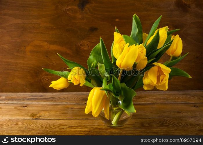 Spring yellow tulips bouquet on wooden background. Spring yellow tulips bouquet on wooden background, copy space. Flowers greeting. Flowers postcard. Spring flowers