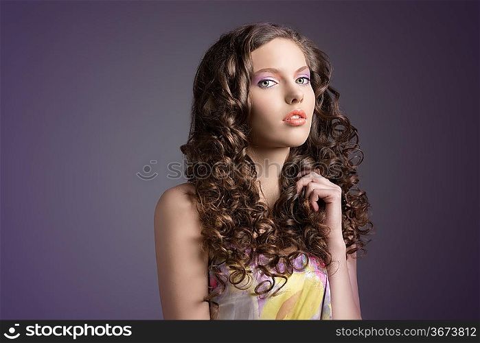 spring young woman with curly hair anf floral dress on dark violet background