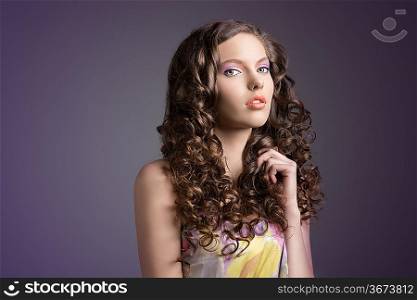 spring young woman with curly hair anf floral dress on dark violet background