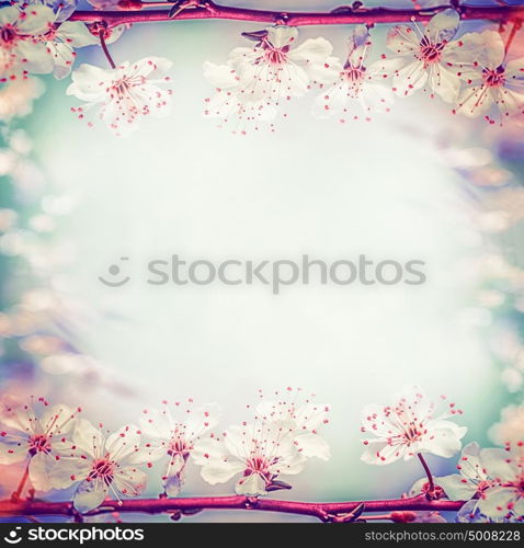 Springtime floral frame with pretty cherry or sakura blossom, at bokeh background