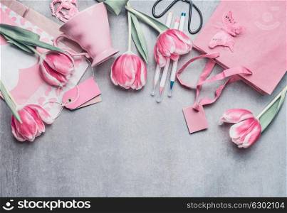 Springtime still life border with pastel pink tulips, hearts, mug m gifts, tags and scissors, top view. Layout or greeting card for Mothers day,birthday, Valentine?s Day, wedding or happy event