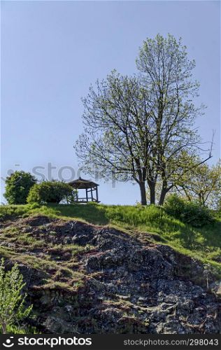 Springtime view with tree and alcove for respite in the glade at top slope, Pancharevo, Sofia, Bulgaria