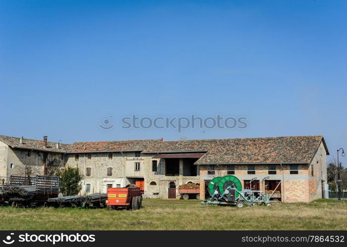 Sprinkler system with pipes and in the background an old farm