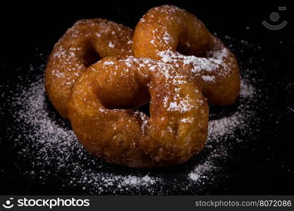 Sprinkling sugar powder on delicious homemade donut