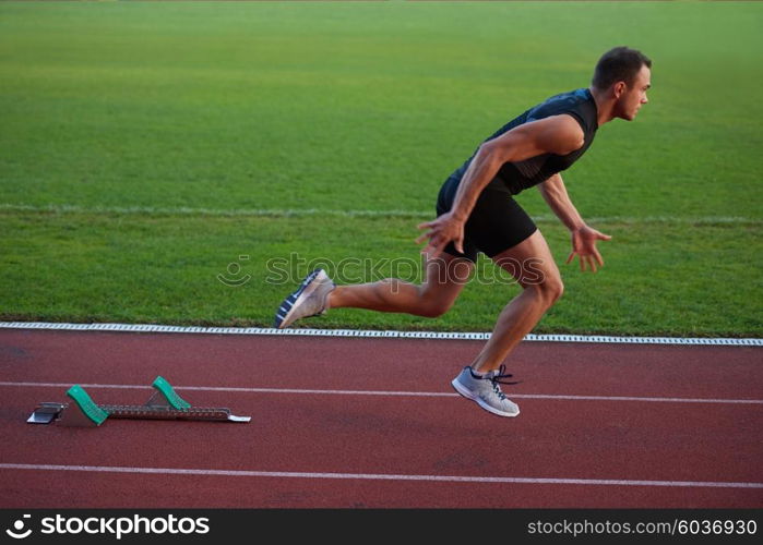 Sprinter leaving starting blocks on the running track. Explosive start.