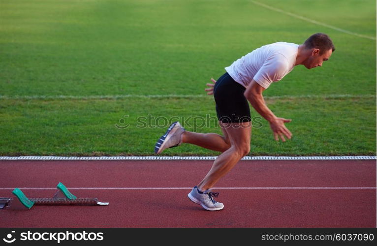 Sprinter leaving starting blocks on the running track. Explosive start.