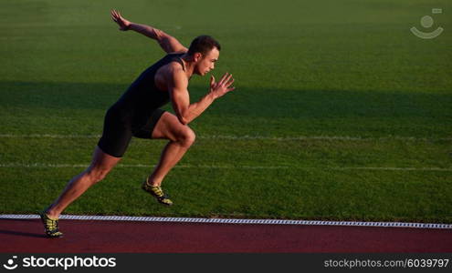 Sprinter leaving starting blocks on the running track. Explosive start.