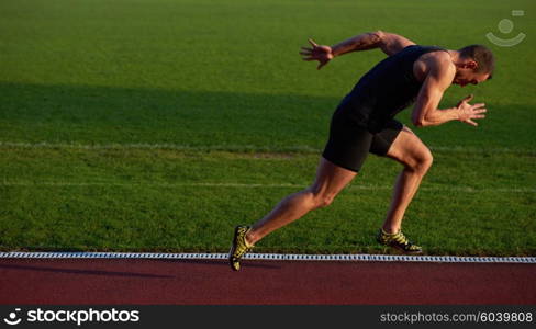 Sprinter leaving starting blocks on the running track. Explosive start.