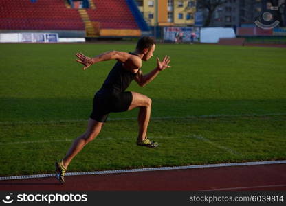 Sprinter leaving starting blocks on the running track. Explosive start.