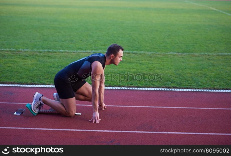 Sprinter leaving starting blocks on the running track. Explosive start.