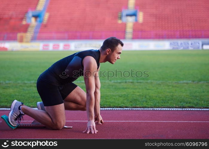 Sprinter leaving starting blocks on the running track. Explosive start.