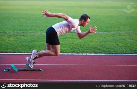 Sprinter leaving starting blocks on the running track. Explosive start.